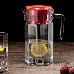 Une carafe en verre avec un couvercle rouge